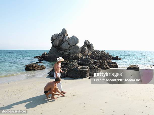 mature couple collecting shell on beach - puerto vallarta stock pictures, royalty-free photos & images