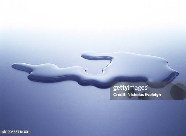 puddle of water on white surface, studio shot - knoeien stockfoto's en -beelden