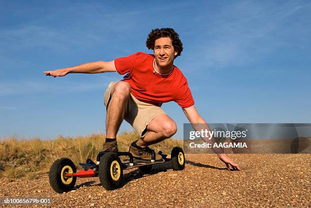mid adult man riding skateboard, looking away, smiling - serra da canastra national park stock pictures, royalty-free photos & images