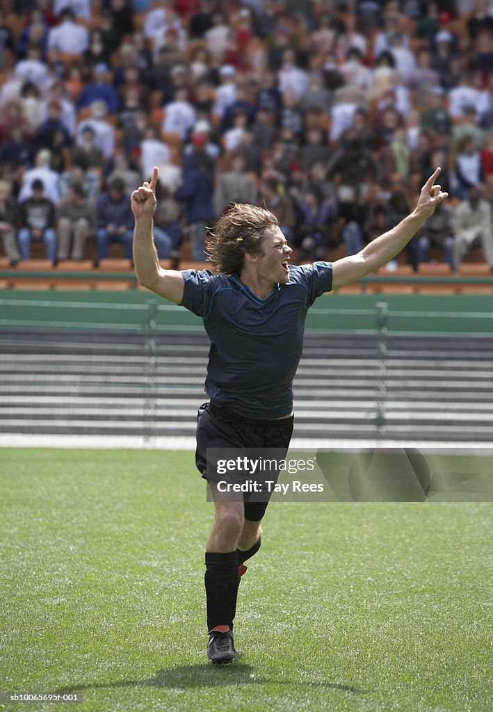 Young man celebrating victory in sports stadium