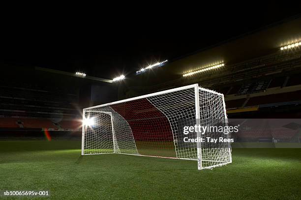 soccer goal in empty floodlit stadium - stadion flutlicht stock-fotos und bilder
