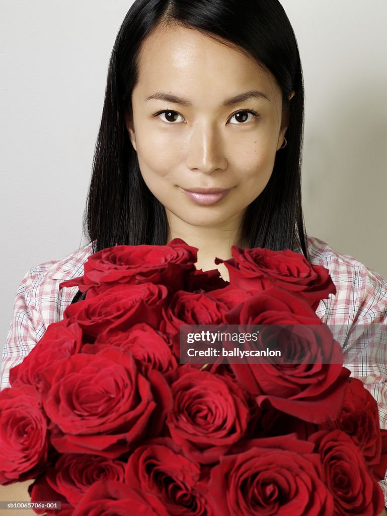 Young woman with bouquet of roses, portrait