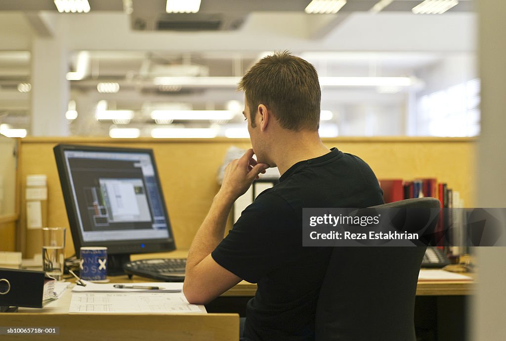 Man using computer in office, rear view