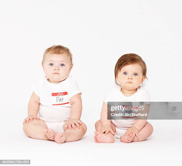 two babies (6-9 months) sitting on white background - baby name stock pictures, royalty-free photos & images