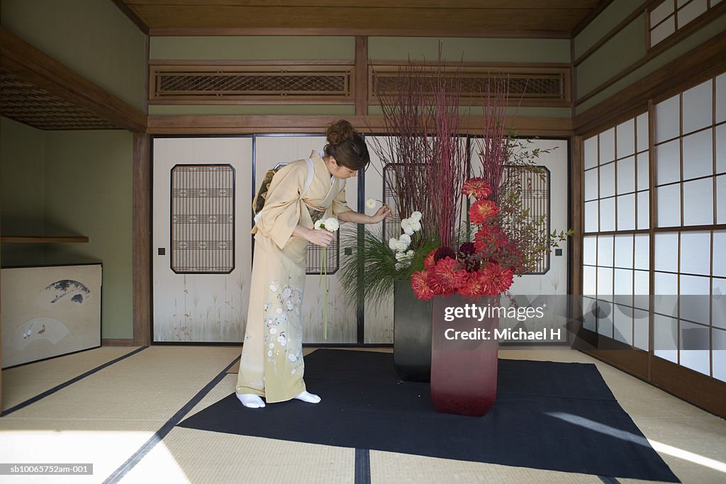 Japan, Tokyo, woman wearing kimono arranging flowers