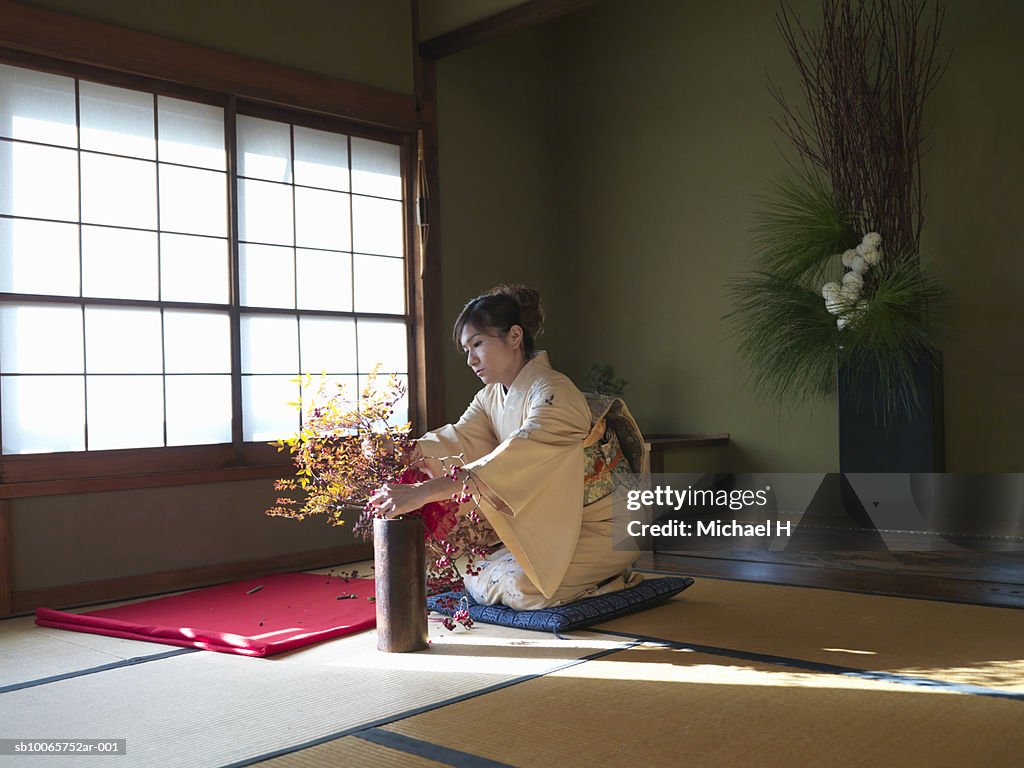 Japan, Tokyo, woman wearing kimono arranging flowers