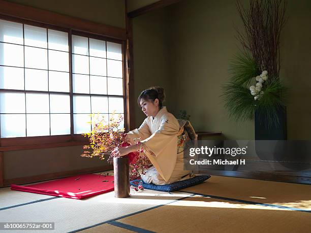 japan, tokyo, woman wearing kimono arranging flowers - ikebana arrangement stock pictures, royalty-free photos & images