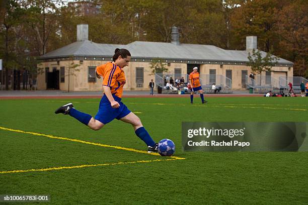 female soccer player kicking ball on field - goal kick stock pictures, royalty-free photos & images