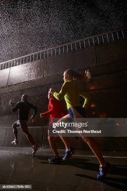 young men and women jogging at night - man running city fotografías e imágenes de stock