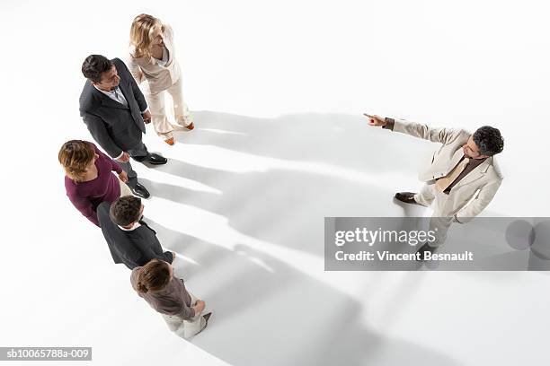 business man pointing at group of business people - face off stock pictures, royalty-free photos & images