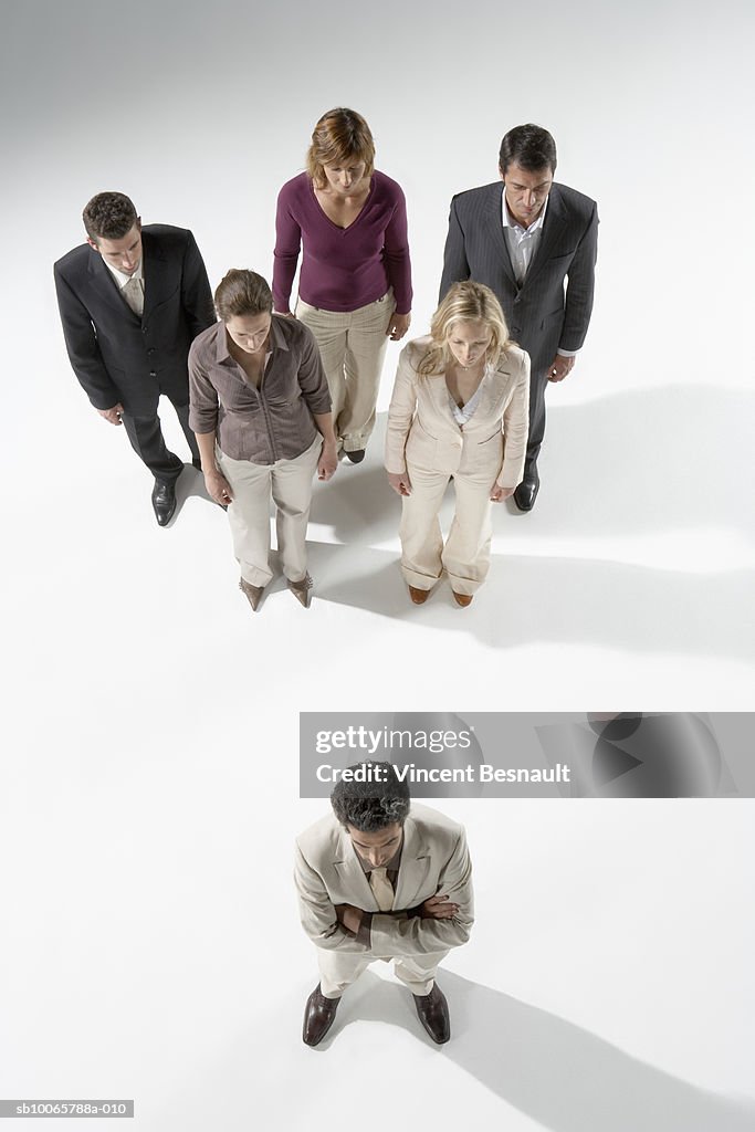 Business People Standing In Triangle Formation With Leader At Front