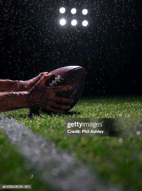 hands of american football player with ball, close-up - campo de fútbol americano fotografías e imágenes de stock