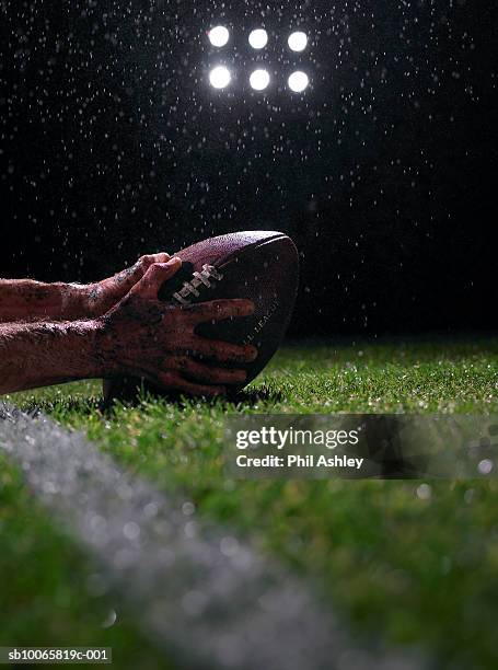 hands of american football player with ball, close-up - アメリカンフットボール場 ストックフォトと画像