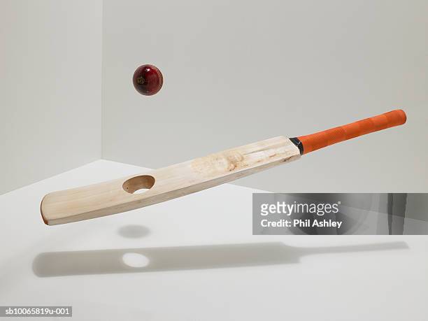 cricket bat and ball on white background, mid air - cricketbat stockfoto's en -beelden