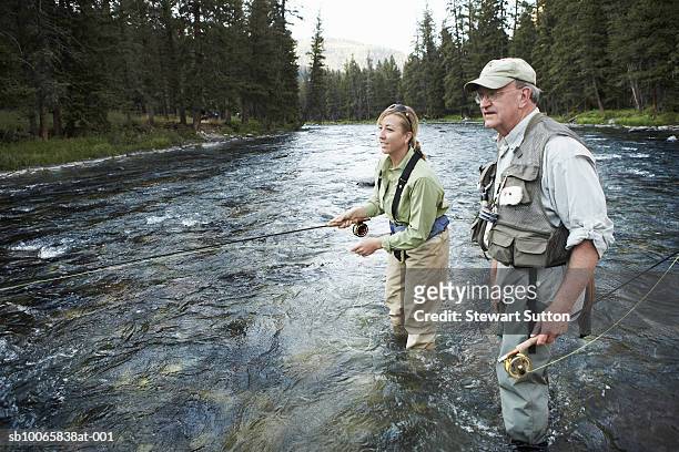 senior man teaching woman fly-fishing - fly fishing fotografías e imágenes de stock