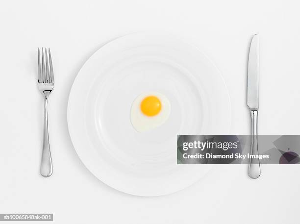 fried egg on plate with knife and fork, close-up - silverware stock pictures, royalty-free photos & images