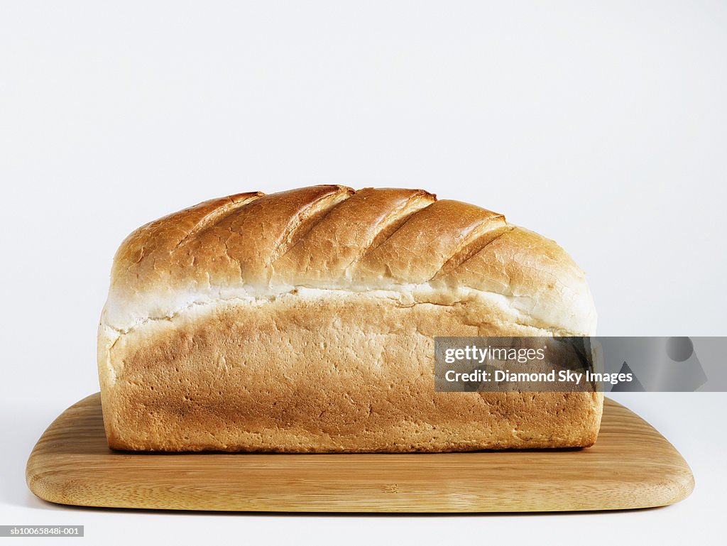 Loaf of bread on chopping board, close-up