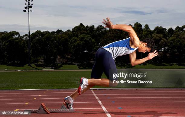 male athlete running from starting block on track - athlete sprint stock pictures, royalty-free photos & images