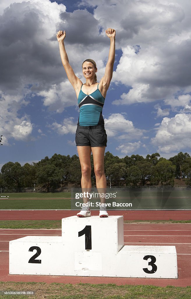 Female athlete on winner's podium on track