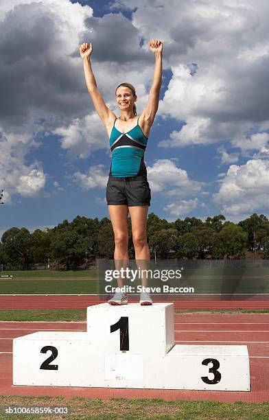 female athlete on winner's podium on track - siegertreppe stock-fotos und bilder