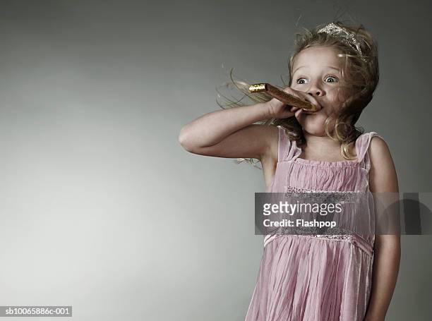 girl (6-7) blowing party blower - matasuegras fotografías e imágenes de stock