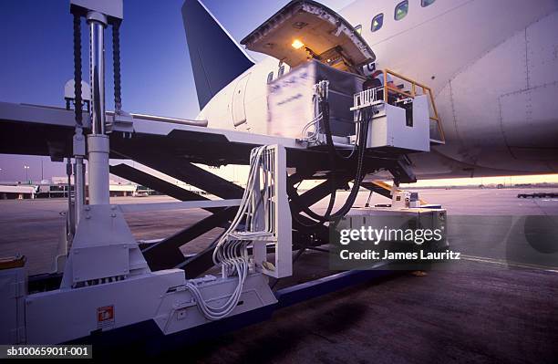 australia, melbourne, freight being loaded into passenger jet at dusk - asphalt roller stock pictures, royalty-free photos & images