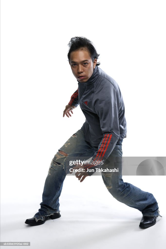 Young man standing against white background, portrait