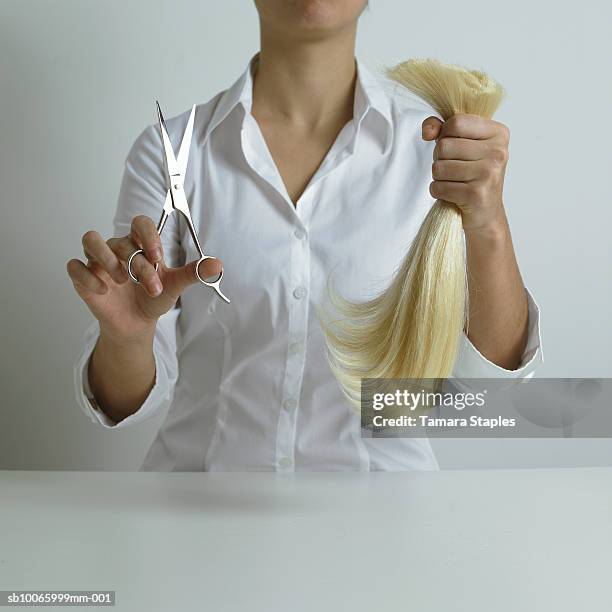 young woman holding scissors and cut blonde pony tail - ponytail hairstyle stock pictures, royalty-free photos & images