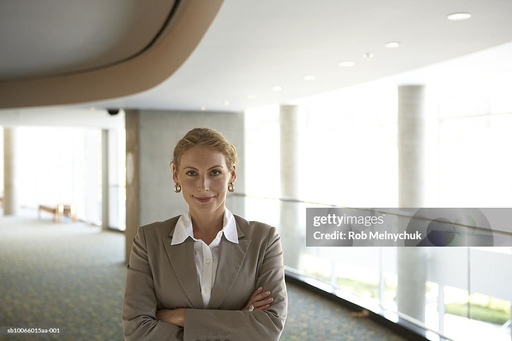 Businesswoman standing in office hallway, portrait