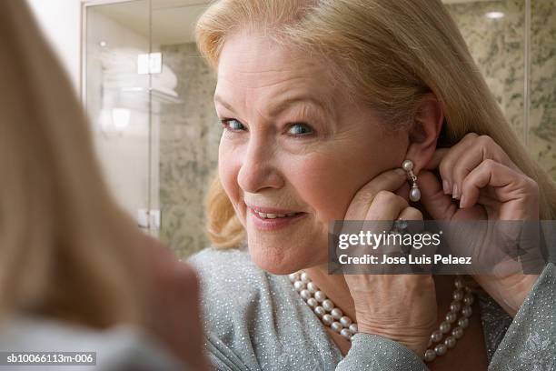 mature women wearing earring, smiling, close-up - collier et femme photos et images de collection