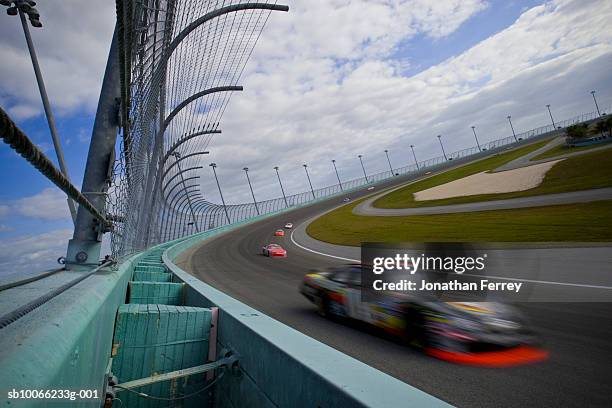 stock cars racing around track (blurred motion) - pista-de-automobilismo imagens e fotografias de stock