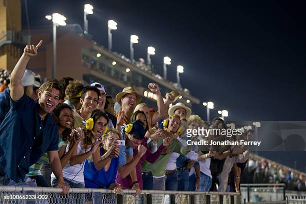 crowd in stadium watching stock car racing, leaning on railings, cheering - crowd cheering stock pictures, royalty-free photos & images