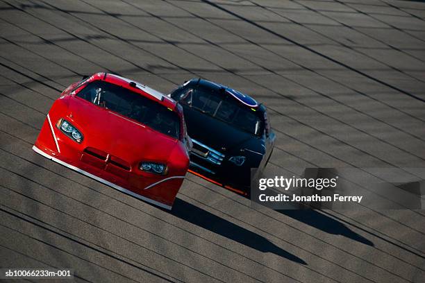 stock cars racing around track - nascar car stock pictures, royalty-free photos & images