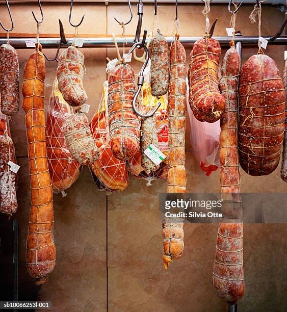 salami and sausages hanging in shop - salami stock pictures, royalty-free photos & images