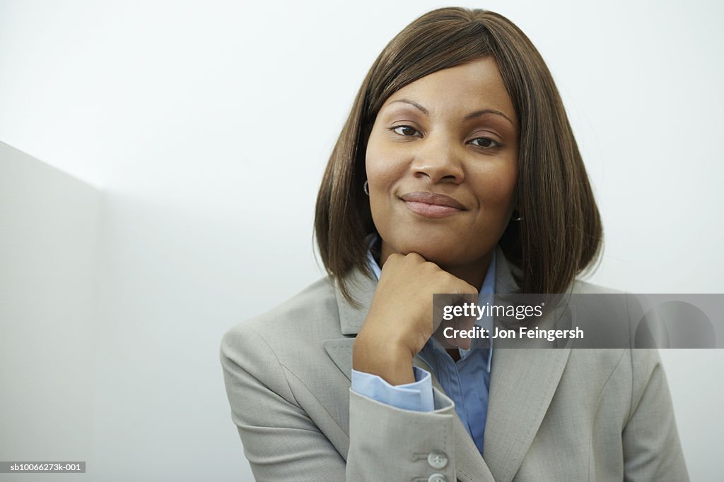 Businesswoman with hand on chin, smiling, portrait, close-up