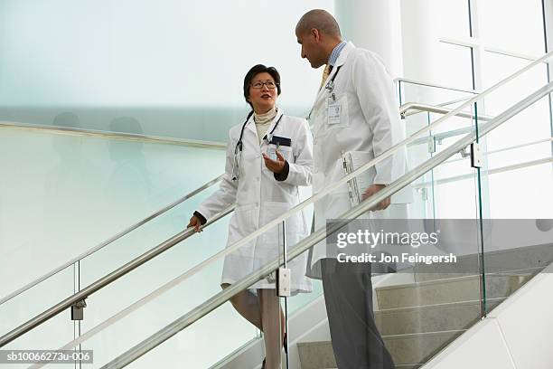 two doctors walking on steps, talking - two doctors talking stockfoto's en -beelden