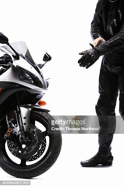 motorcyclist putting on glove - sporthandschuh stock-fotos und bilder