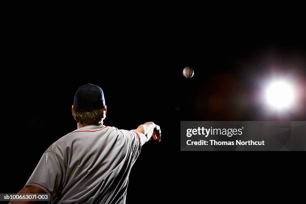 baseball player throwing ball, rear view - baseball thrower stock pictures, royalty-free photos & images