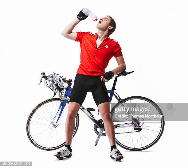 cyclist standing in front of racing bicycle, drinking water - fatigue full body stock-fotos und bilder