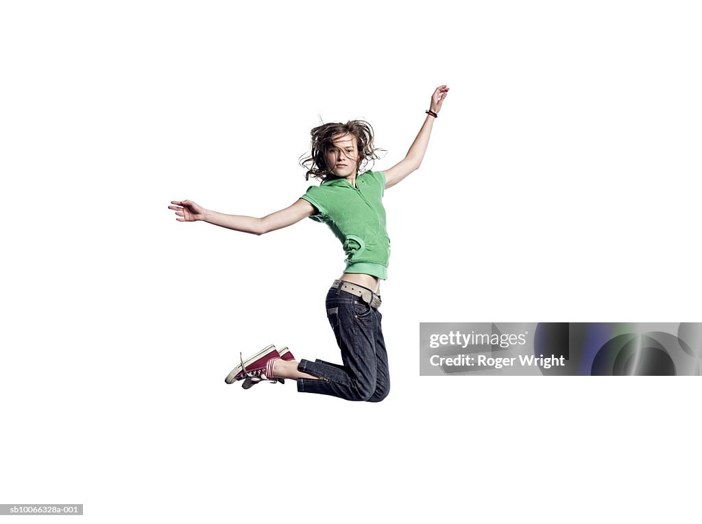 Teenage girl (16-17) jumping in air, portrait