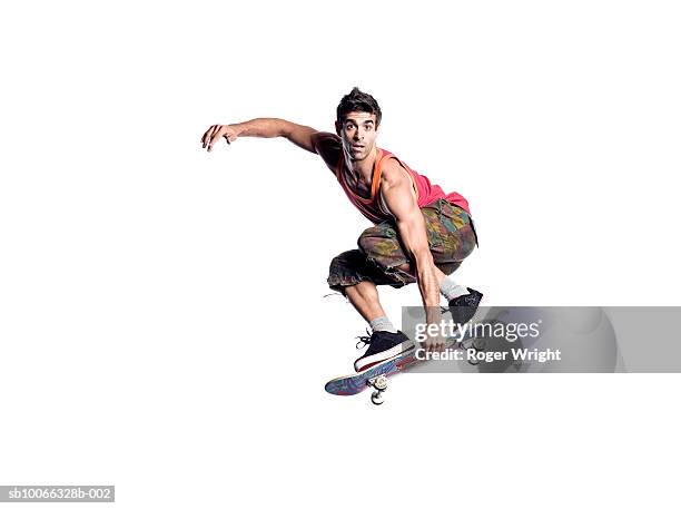man performing jump on skateboard - skateboard foto e immagini stock