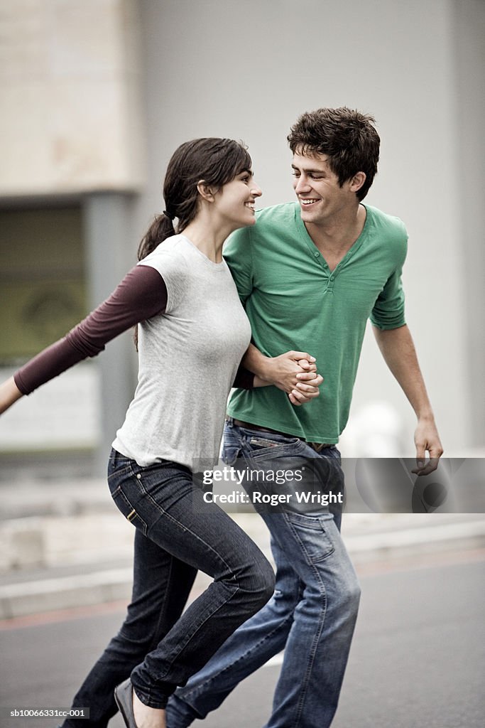 Young couple running in street