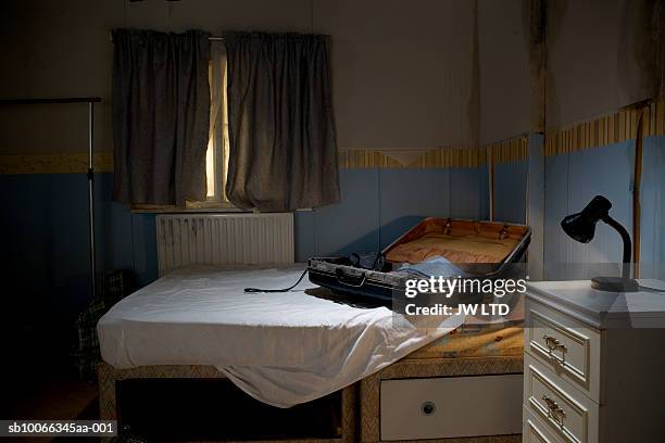 open suitcase on bed - motel stockfoto's en -beelden