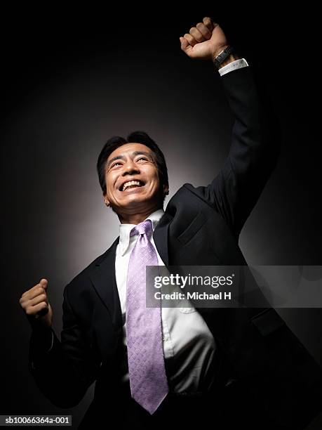 businessman looking up with clenching fist, smiling, close-up - male portrait suit and tie 40 year old stock pictures, royalty-free photos & images