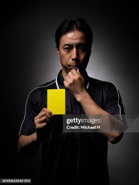 soccer referee blowing whistle and holding yellow card, portrait, close-up - referee stock pictures, royalty-free photos & images