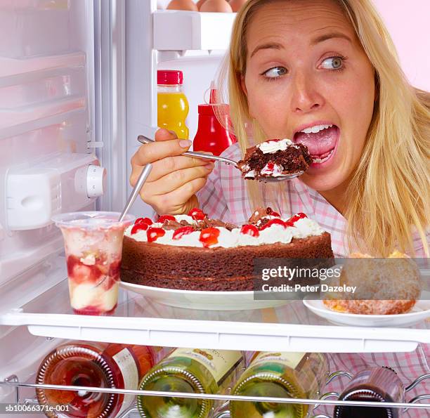 young woman eating chocolate cake inside fridge - bulimia 個照片及圖片檔