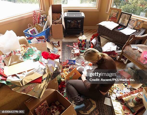 woman sitting in living room writing on christmas cards, elevated view - wrapping paper mess stock pictures, royalty-free photos & images