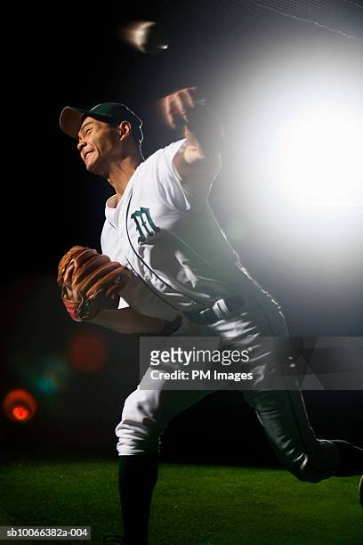 baseball pitcher releasing ball, grimacing, (lens flare, blurred motion) - baseball pitcher close up stock pictures, royalty-free photos & images