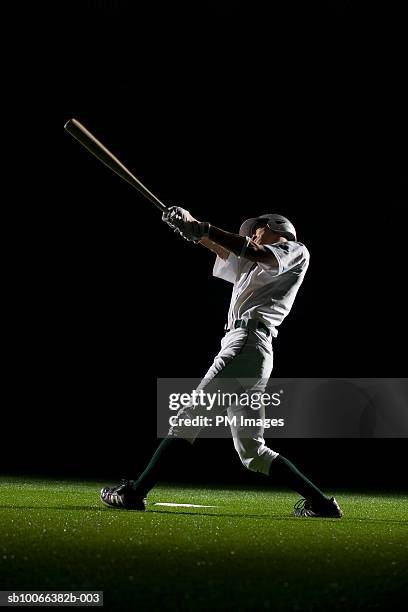 baseball batter swinging bat, side view - bat stockfoto's en -beelden