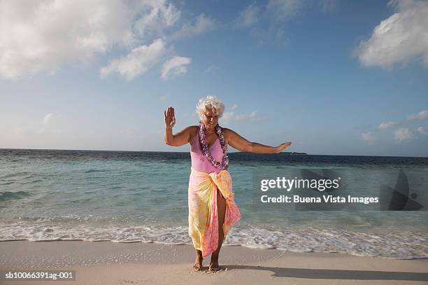 senior woman with garland dancing on beach, smiling - old woman in swimsuit imagens e fotografias de stock